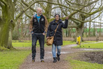 Twee personen lopen over een pad in het bos