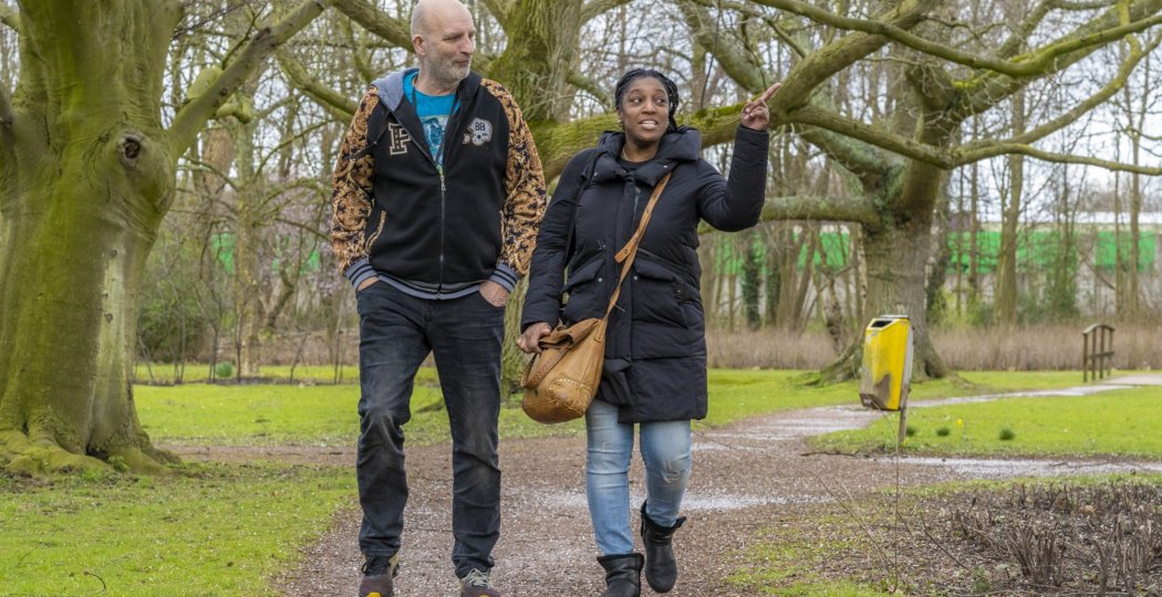 Twee personen lopen over een pad in het bos